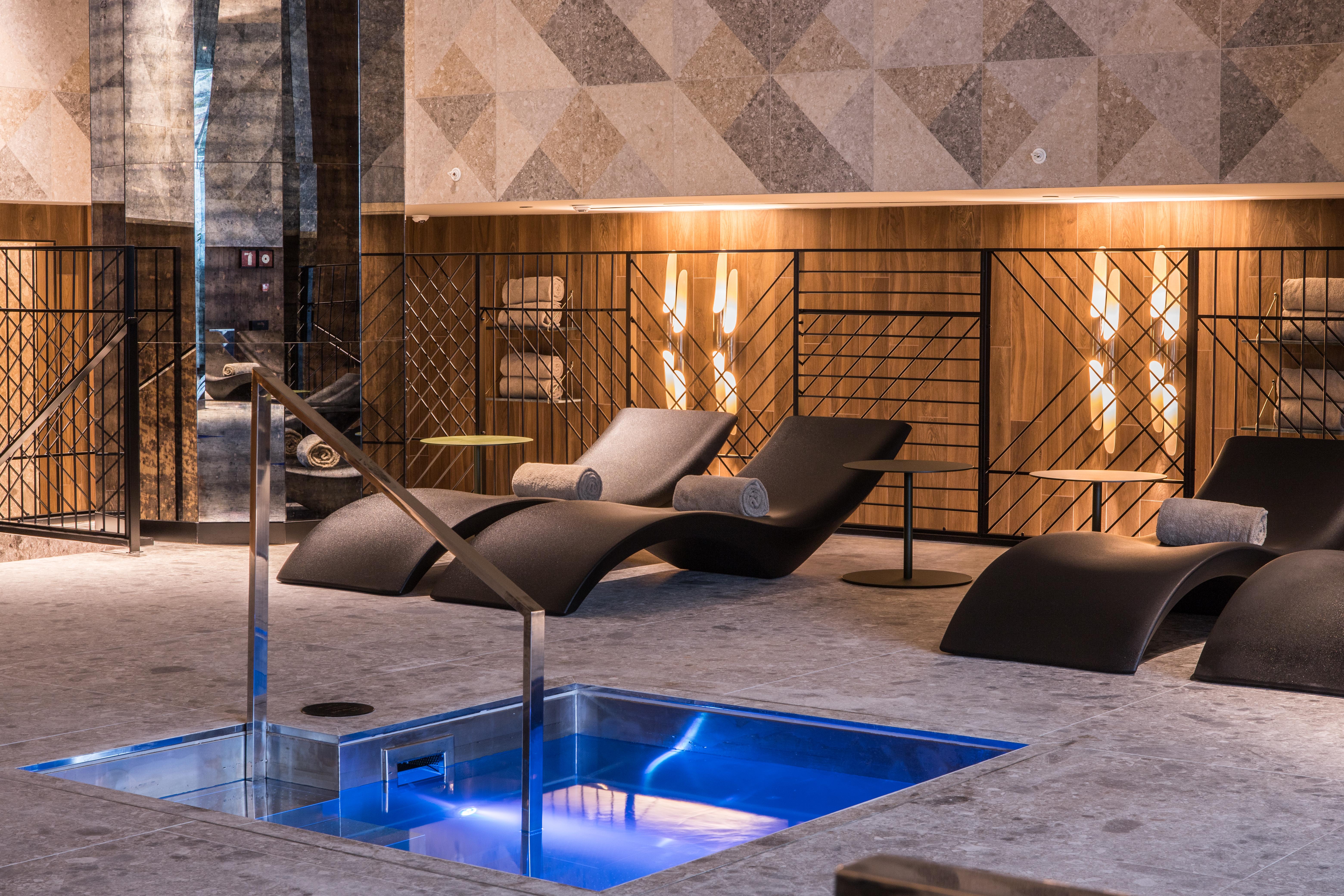 Hotel Grand Hyatt Barcelona Exteriér fotografie The photo shows a modern spa or relaxation area. In the foreground, there is a small rectangular pool of water with a sleek metal railing. Surrounding the pool are comfortable lounge chairs, designed for relaxation, likely positioned for users to unw